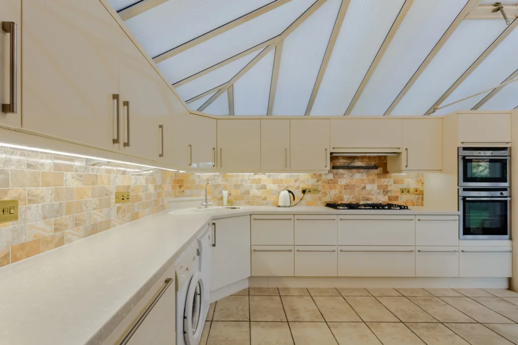 Modern kitchen with tiled backsplash and white cabinets.